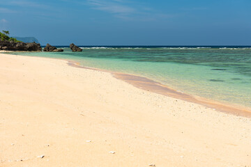 Suuny day on an icredible hidden beach. Stunning emerald green sea full of corals, blue sky, some rocks at the bottom and a smooth sand inviting you to an unforgettable day off in Gaia.
