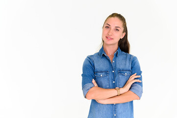 Portrait of beautiful woman in blue jeans shirt, crossed arms posing and standing on white background with copy space. Looking at camera