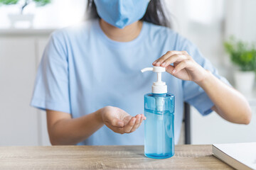 Woman using hand sanitizer alcohol gel bottle cleaning to prevent spreading of coronavirus, Covid-19..