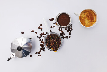 Still life with moka pot, coffee beans and fresh hot espresso in a cup