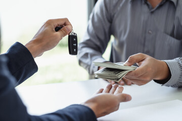 Businessman agent holding car keys offering new car salesman Automobile Vehicles Concept