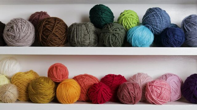 Colorful Balls Of Wool On Shelf. Different Yarn balls in multiple colors. 
