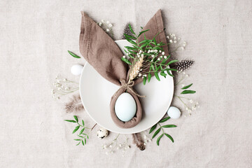 Fototapeta na wymiar Easter table setting, napkin with bunny ears, natural festive composition