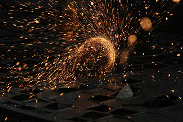 Steel cutter grinder and sparks in workshop.