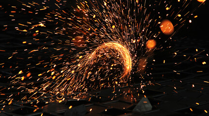 Steel cutter grinder and sparks in workshop.