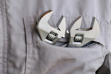 作業服を着た男性とモンキーレンチ