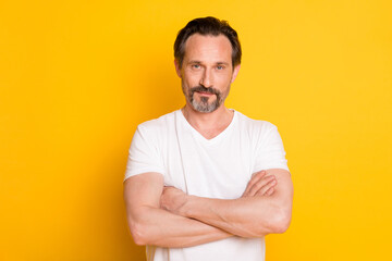 Obraz premium Photo of self-assured mature bearded guy crossed hands wear white t-shirt isolated yellow background