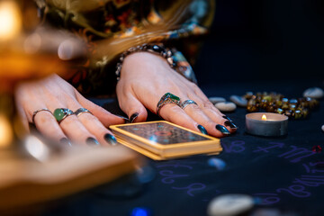Astrology. Witch hands and tarot cards close-up. The foreground is in a blur. The concept of witchcraft and divination - obrazy, fototapety, plakaty