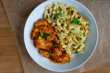 Spaetzle or Spätzle egg noodle pasta with chicken, onions and seasoning. Traditional European cuisine dish (Swabian, German, Austrian, Hungarian). Delicious gluten free Knöpfle bowl. Top view