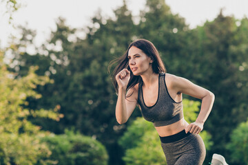 Portrait of attractive motivated girl doing workout in wood running healthcare day shaping outdoor