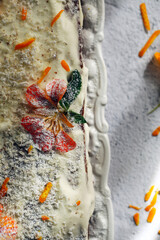 bolo de cenoura festivo está na mesa decorada com flores. 