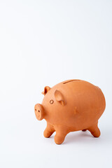 Top view of clay pig piggy bank on white background, vertical, with copy space