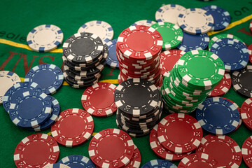 Gambling chips on green table in casino