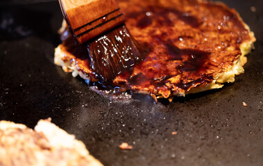 お好み焼にソースを塗る