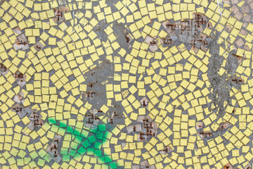 Old yellow mosaic wall with hole and rust, background from old mosaic.