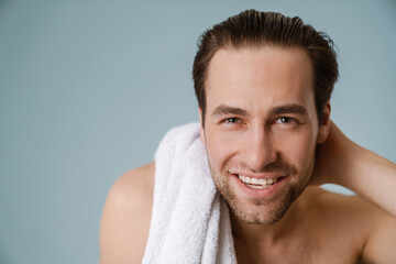 Shirtless white man smiling at camera while posing with towel