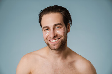Naklejka premium Shirtless white man with under eye patches smiling at camera