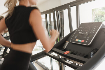Athletic woman running on treadmill during fitness workout
