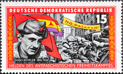 a postage stamp from Germany, GDR showing a portrait of Hans Beimler, street fight in Madrid under...