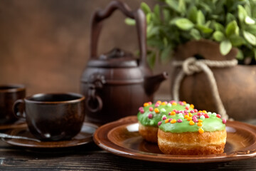 Bun, donut covered with glaze. Tutti frutti bun on a plate. Sweet pastries. Dessert. Still life. Close-up.