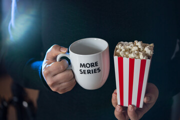 Home Cinema. Watching tv series with a cup of tea that say more series and pop corn