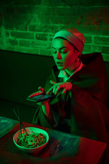 Fototapeta premium Beautiful girl with a pearl earring taking lunch in modern cafe, restaurant in neon light
