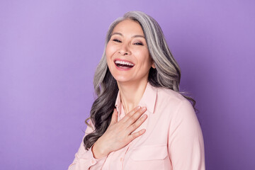 Portrait of attractive cheerful pleased grey-haired woman laughing having fun isolated over violet...