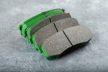 a set of new green brake pads on a gray table