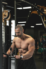 Fototapeta na wymiar Muscular bodybuilder during his workout in the gym