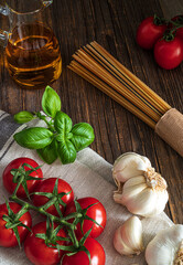 Spaghetti,tomatoes,basil,garlic and olive oil.Ingredients for italien pasta.Rustic food photography.