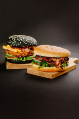 Black loaf burger and white loaf burger on dark background