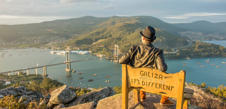 Young man enjoying the views of the bridge in sea loch