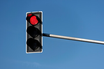 Traffic light with red light against the evening sky.