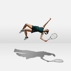 Young caucasian professional sportswoman levitating, flying while playing tennis isolated on white background