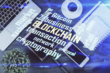 Double exposure of blockchain theme hologram over table with phone. Top view. Crypto technology...