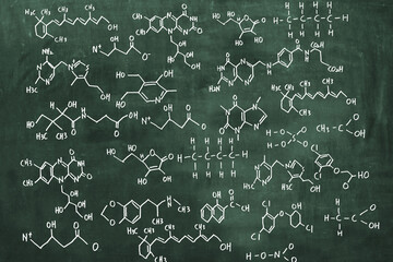 Various chemical formulas are written on the blackboard. Scientific concept background.