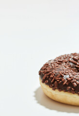 Your favourite dessert. Close up shot of a freshly baked delicious chocolate donut with sprinkles on white background
