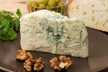 Piece of blue cheese with blue-grey mold on dish