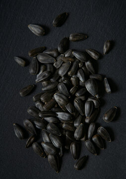 black sun flower seeds on black stone surface