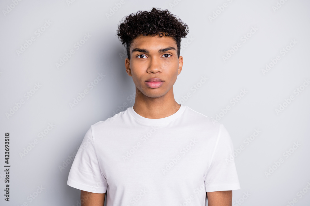 Sticker Portrait of brunet serious curly guy wear white t-shirt isolated on grey color background