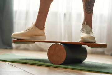 Wooden balance board with man standing on it