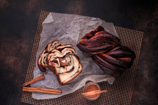 Chocolate cinnamon brioche bread. Homemade Cinnamon twisted loaf bread or babka on a dark background. 