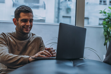 young man at home working with laptop