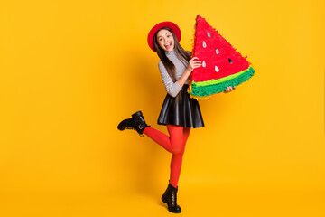 Full length body size view of pretty trendy cheerful girl holding in hands watermelon board having fun isolated on bright yellow color background
