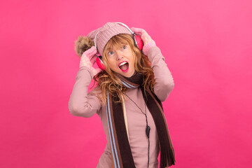 adult woman with headphones and warm or winter clothes dancing isolated