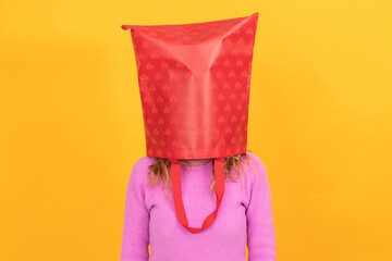 isolated woman with shopping bag on head stressed