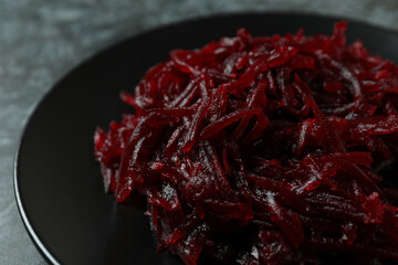 Plate with fresh beet salad on black smoky background