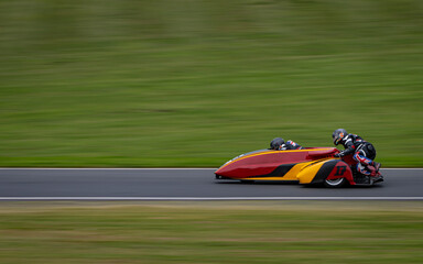 A panning shot of a racing sidecar as it corners on a track.