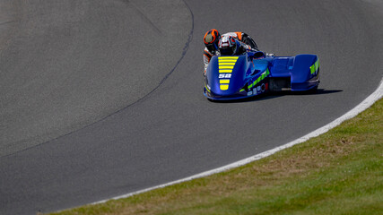 A shot of a racing sidecar as it corners on a track.