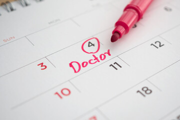important doctor appointment schedule write on white calendar page date close up